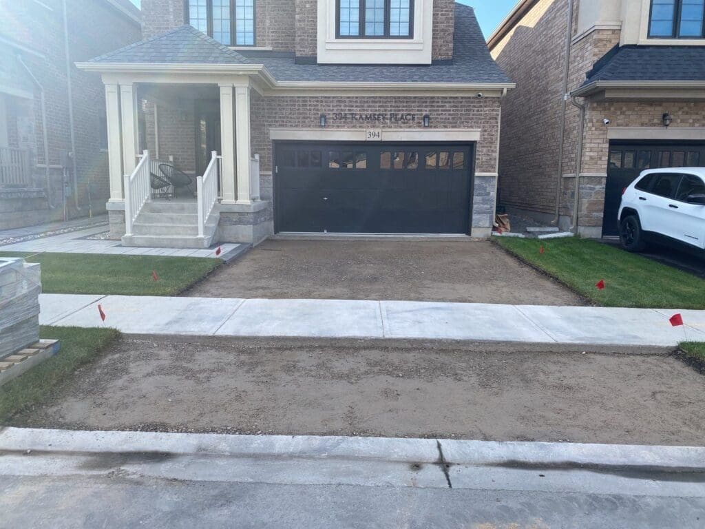 Exposed gravel underneath an asphalt driveway with the asphalt removed.