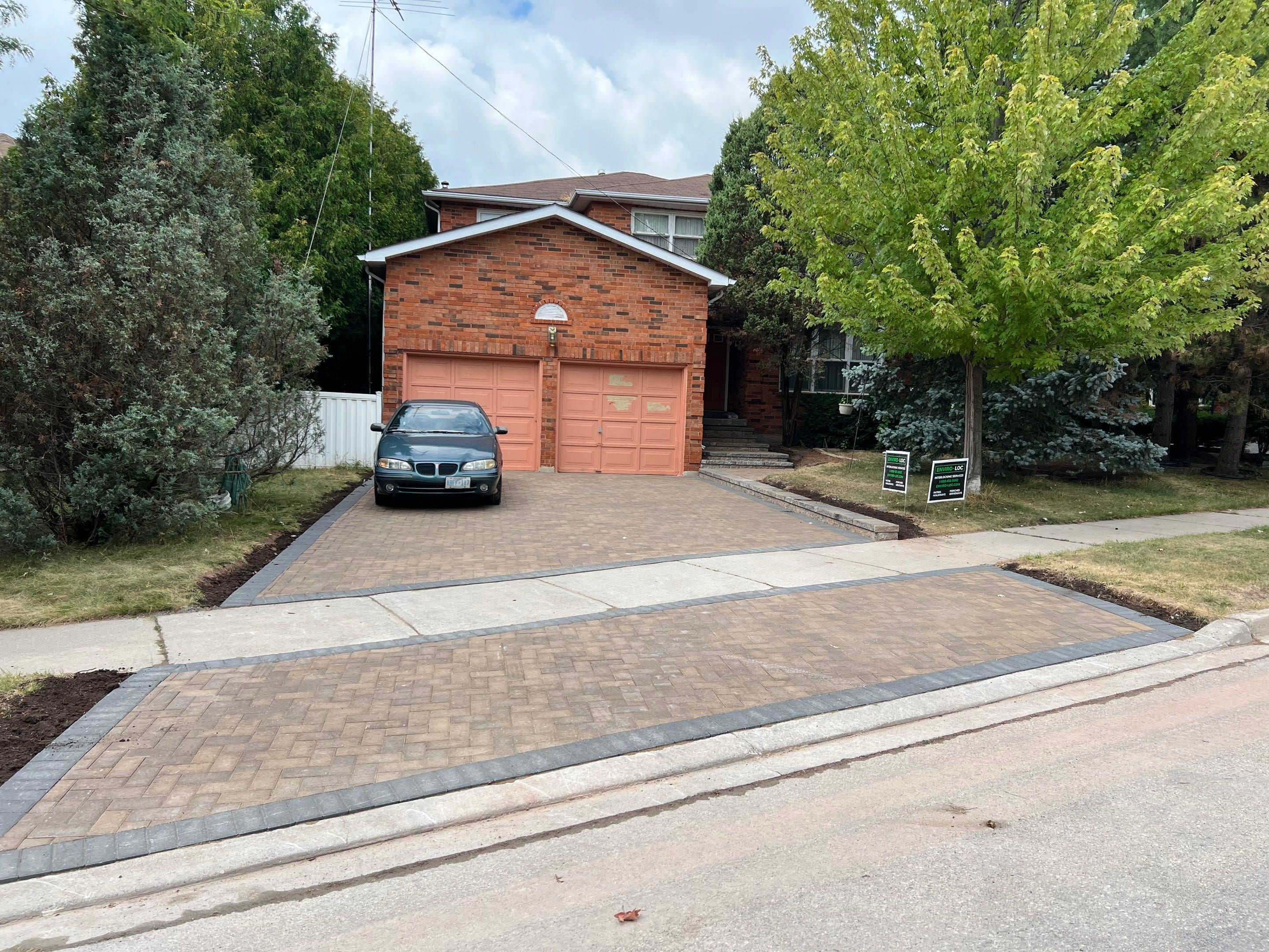 Interlocking driveway that includes a sidewalk separating the driveway.