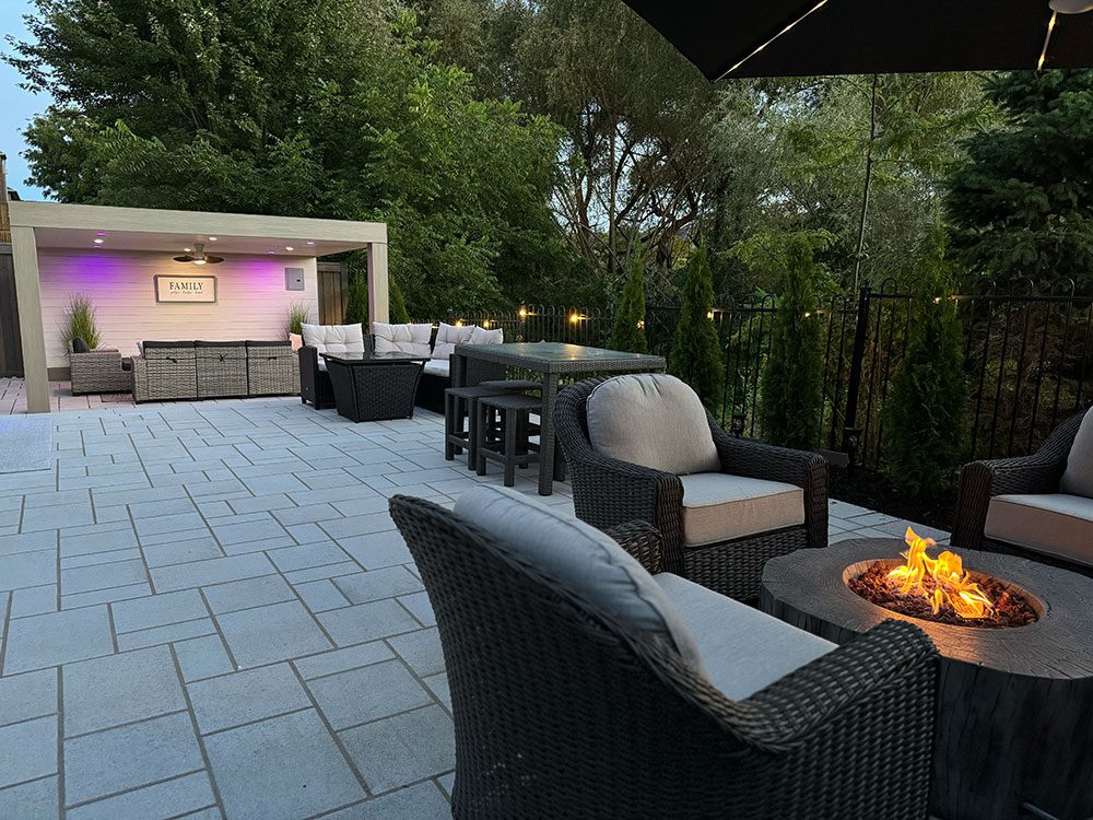 Property exemplifying interlocking paver stone work on a patio in larger backyard space