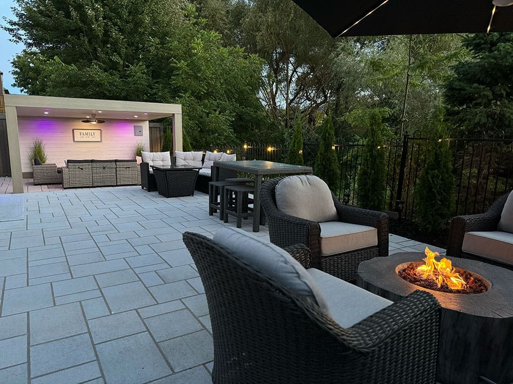 Property exemplifying interlocking paver stone work on a patio in larger backyard space