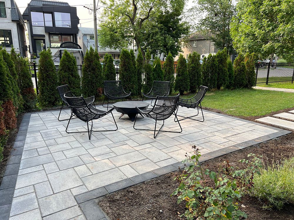 Property exemplifying interlocking paver stone work on a patio in a smaller backyard space