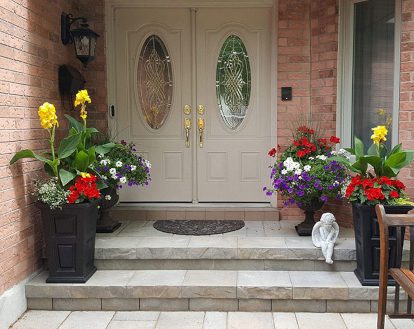 A small 2 step front porch with a small platform exemplifying paver stone work on a small porch