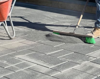 Paver stones being treated with a new layer of polymeric sand on top, exemplifying Pressure Wash and New Polymeric Sand services