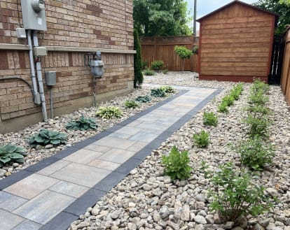 Paver stone walkway with large sections of round stones on either side, exemplifying River Stone work