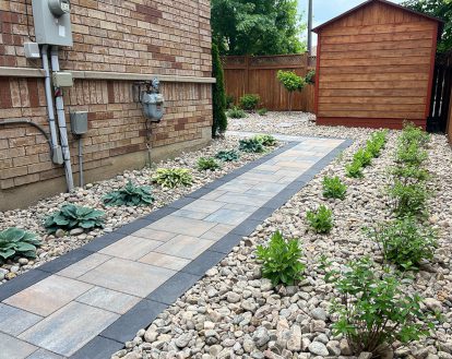 Narrow paver stone walkway consisting of rectangular pavers of varying sizes colours travelling along the side of a house and turning into a backyard, exemplifying Interlocking stone walkways on a medium-sized walkway