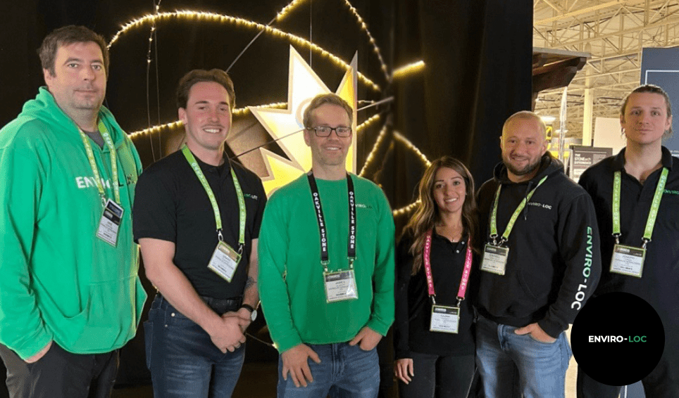 The Enviro-loc team posing in front of a curtain at a tradeshow