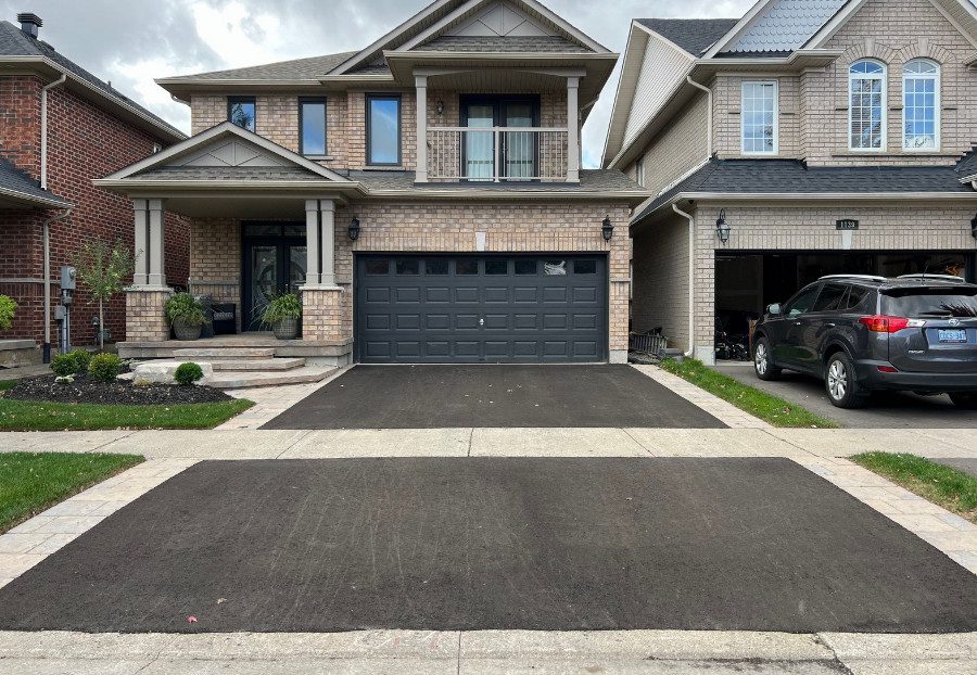Residential property with grey paver stones lining the left and right side of its paved driveway.