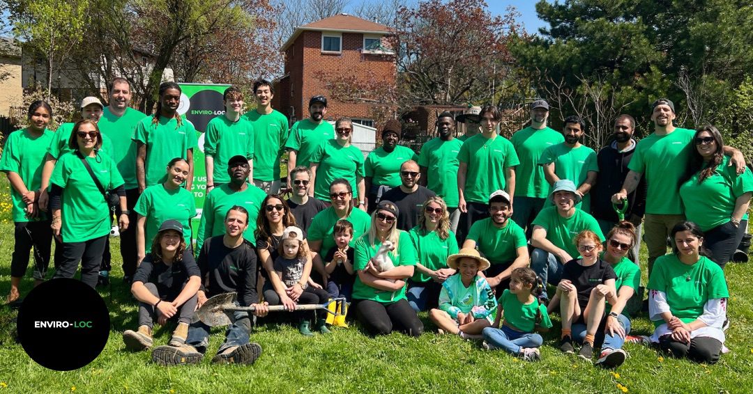 The Enviro-loc team and a group of individuals standing in green grass in a park.