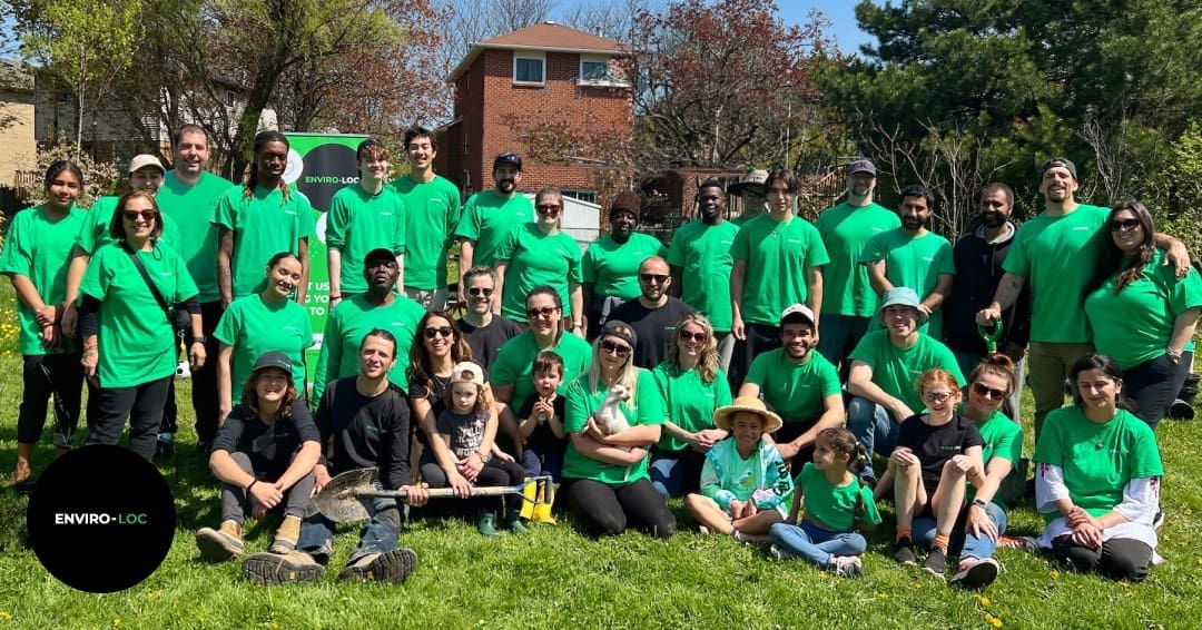 The Enviro-loc team and a group of individuals standing in green grass in a park.