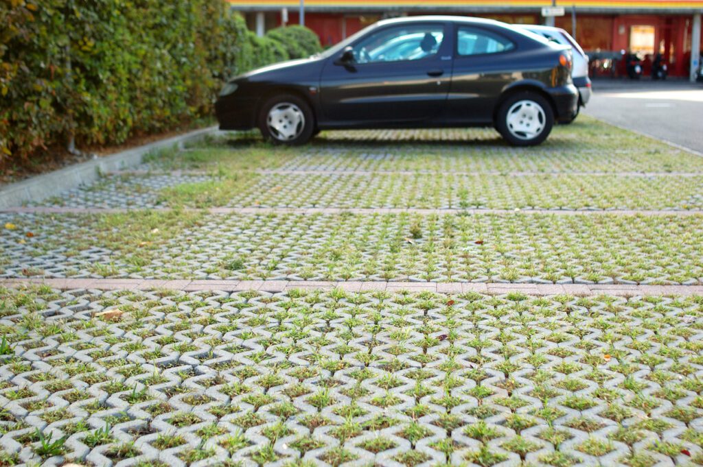 Permeable interlocking paver parking area with grass-filled joints, part of a sustainable landscaping design.