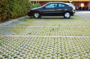 Permeable interlocking paver parking area with grass-filled joints, part of a sustainable landscaping design.