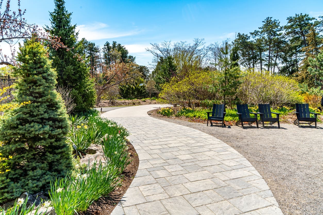 Elegant home with a spacious interlocking stone driveway and manicured front lawn, showcasing curb appeal and functional design.