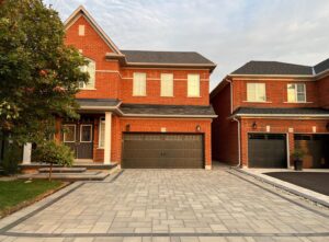 Modern interlock driveway in front of a brick home in Ontario prepared for winter maintenance.