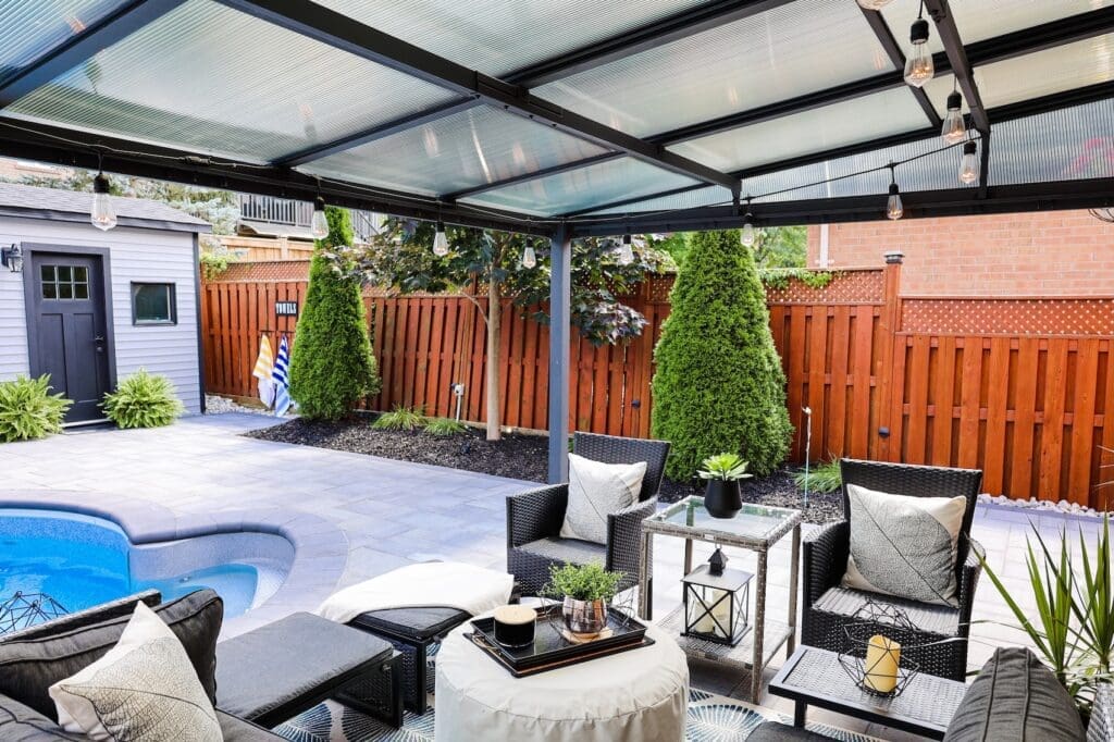 Stylish backyard lounge area with interlocking stone patio, modern pergola and poolside seating, perfect for multi-functional outdoor living