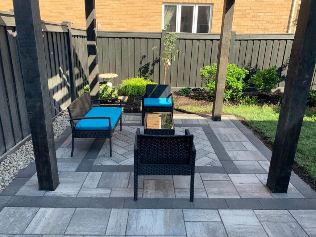 Finished backyard interlocking patio design in Oakville with outdoor furniture and modern layout.